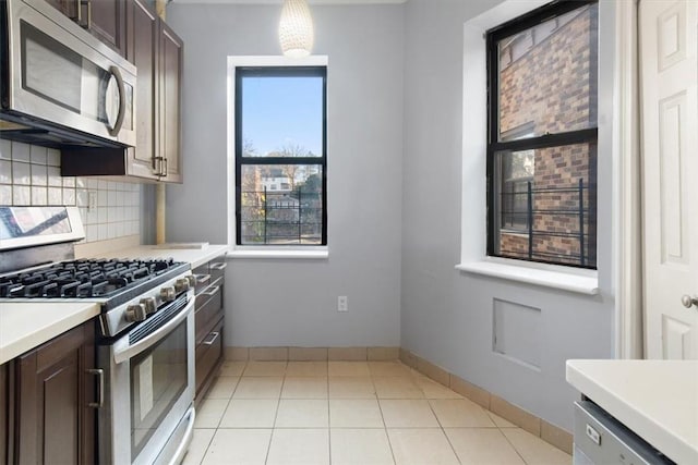 kitchen featuring decorative backsplash, dark brown cabinets, and stainless steel appliances