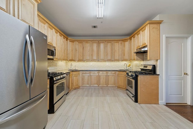 kitchen with appliances with stainless steel finishes, light brown cabinets, tasteful backsplash, and sink