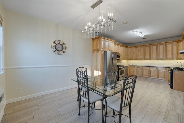 dining area featuring a notable chandelier, light wood-type flooring, and sink