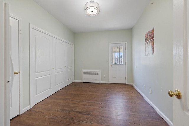 foyer entrance featuring radiator heating unit and dark hardwood / wood-style flooring