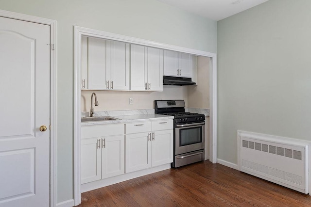 kitchen with radiator heating unit, stainless steel gas stove, dark hardwood / wood-style floors, and sink