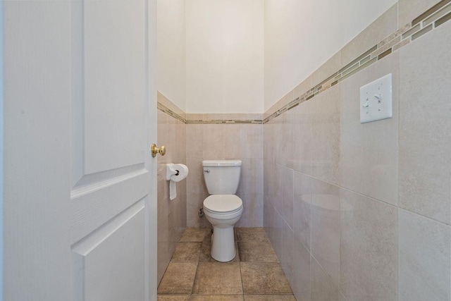 bathroom featuring tile patterned floors, tile walls, and toilet