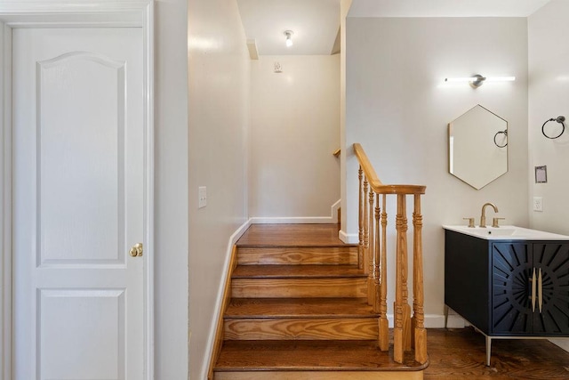 stairway with hardwood / wood-style floors and sink