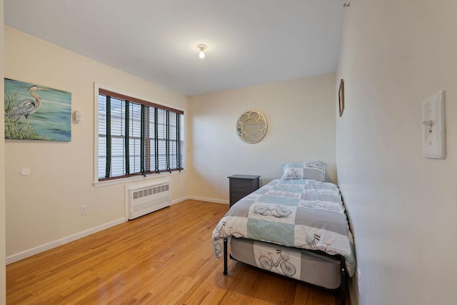 bedroom featuring light wood-type flooring and radiator heating unit