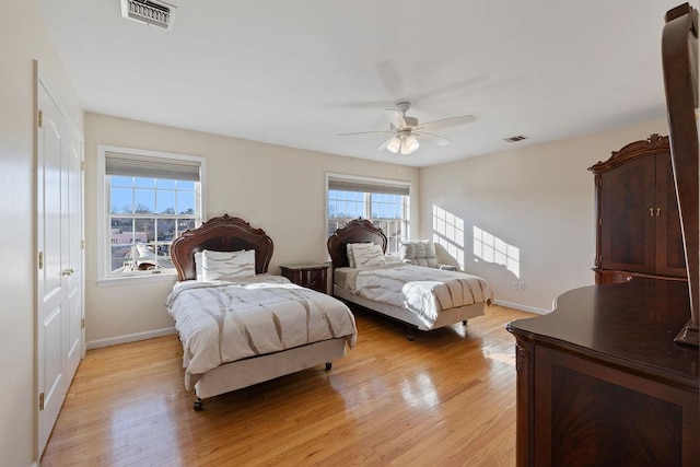 bedroom with multiple windows, ceiling fan, and light wood-type flooring