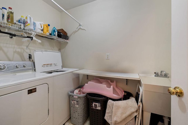 laundry area with separate washer and dryer and sink