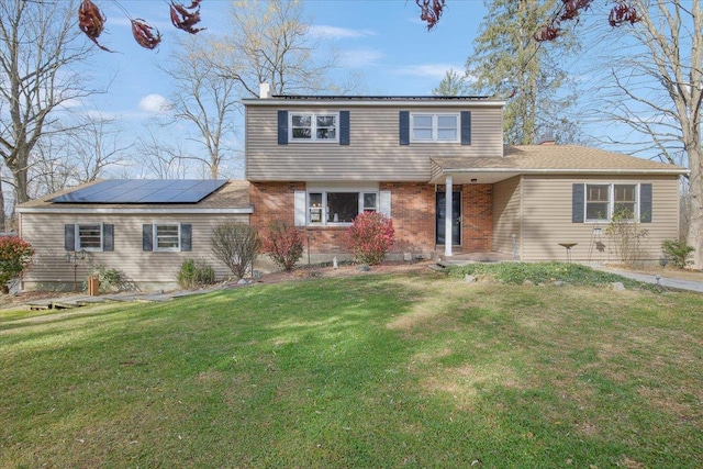 view of property with solar panels and a front lawn