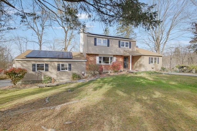 view of front facade with solar panels and a front yard