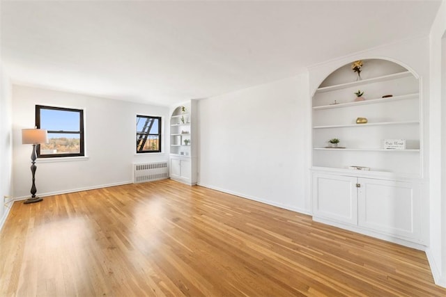 19 Old Mamaroneck Rd Unit 6D, White Plains, NY 10605 - empty room featuring radiator heating unit, built in shelves, light wood-type flooring, and baseboards