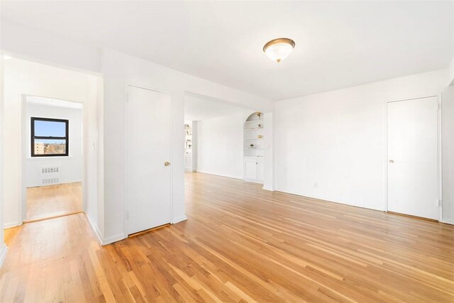 unfurnished room featuring light wood-type flooring and radiator