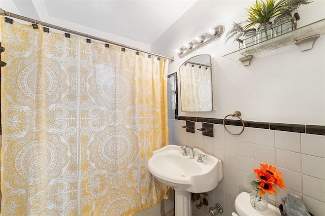 bathroom with a shower with curtain, toilet, tile walls, and sink