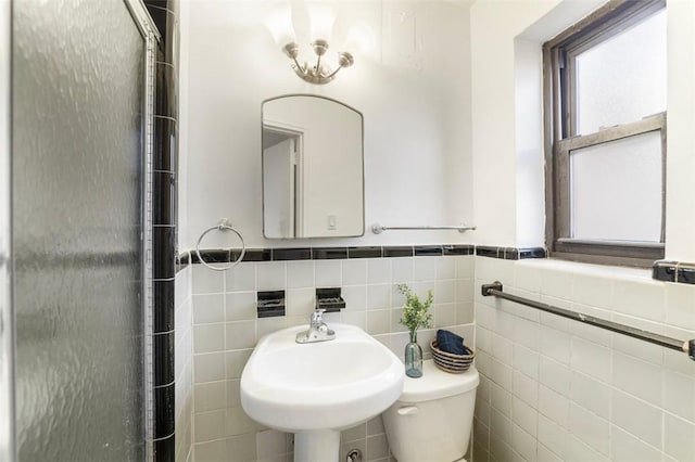 bathroom with sink, tile walls, and toilet