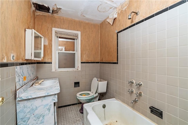 bathroom featuring vanity, tile patterned floors, toilet, a tub to relax in, and tile walls