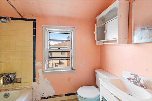 full bathroom featuring vanity, tiled shower / bath combo, and toilet