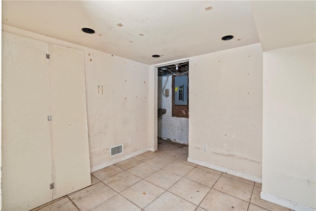 unfurnished bedroom with light tile patterned floors and electric panel