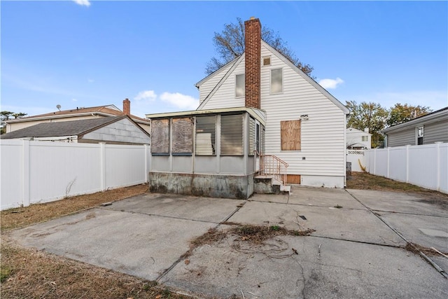 rear view of house with a sunroom and a patio