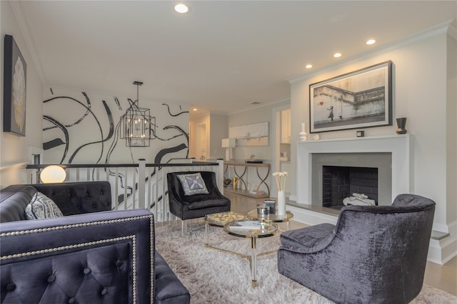 living area featuring recessed lighting, a fireplace with raised hearth, and crown molding