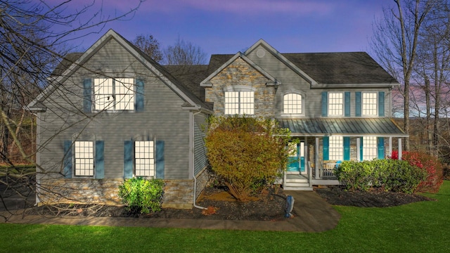 view of front of house with a yard and a porch