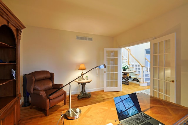 living area featuring french doors and hardwood / wood-style flooring