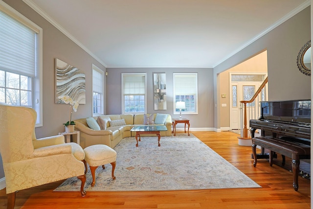 living room featuring crown molding, plenty of natural light, and light hardwood / wood-style floors