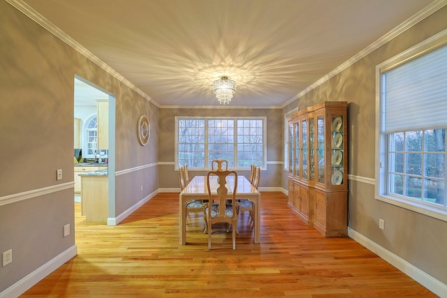 dining room featuring light hardwood / wood-style floors, a notable chandelier, and ornamental molding