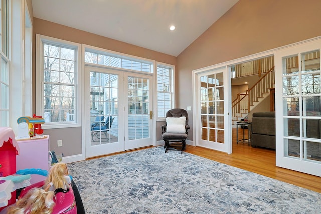 sunroom featuring lofted ceiling, a wealth of natural light, and french doors