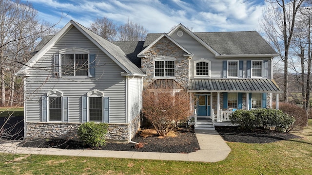 front facade with covered porch and a front yard