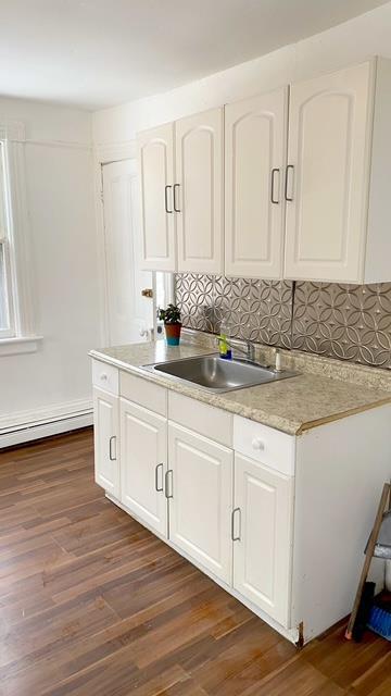 kitchen featuring dark hardwood / wood-style flooring, sink, decorative backsplash, and white cabinets