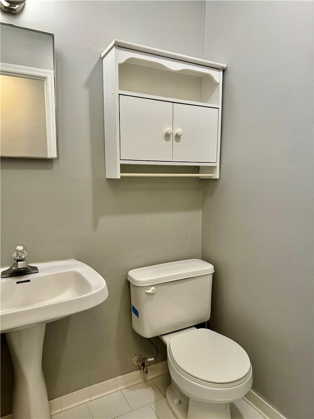 bathroom featuring toilet, tile patterned floors, and sink