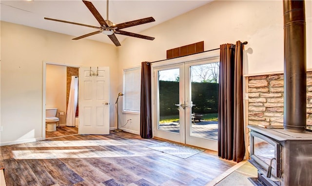 doorway to outside featuring a wood stove, ceiling fan, and light hardwood / wood-style floors