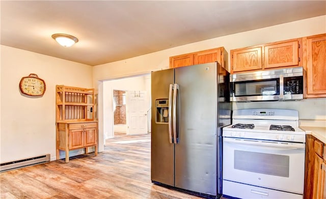 kitchen with light wood-type flooring, appliances with stainless steel finishes, and a baseboard heating unit