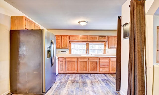 kitchen with stainless steel fridge, light hardwood / wood-style floors, and sink