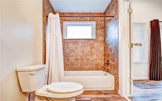 bathroom with wood-type flooring, shower / bath combo, and toilet