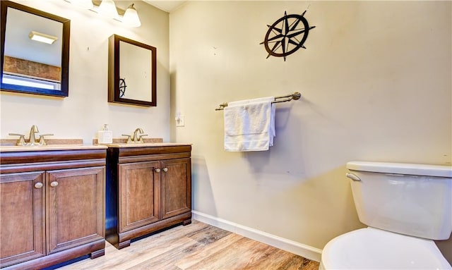 bathroom featuring wood-type flooring, vanity, and toilet