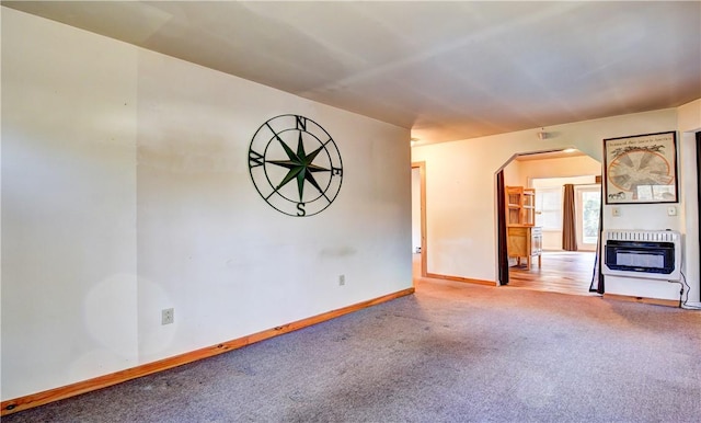 unfurnished living room with carpet and heating unit