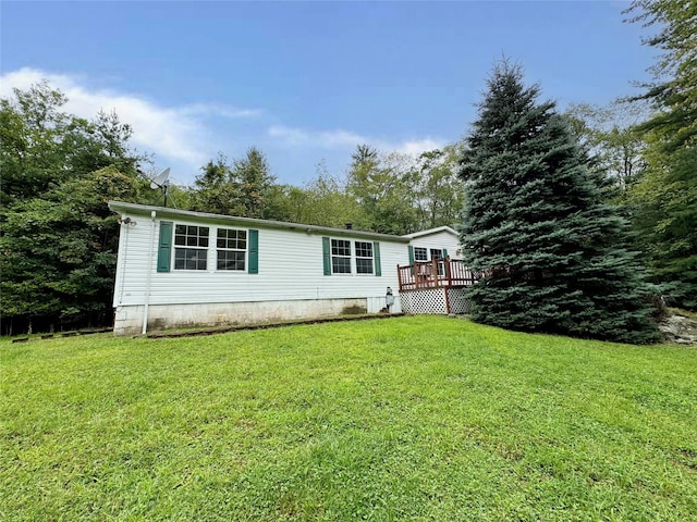 back of property featuring a lawn and a deck