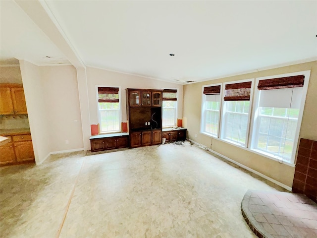 unfurnished living room with vaulted ceiling and plenty of natural light