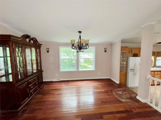 unfurnished dining area featuring dark hardwood / wood-style flooring, an inviting chandelier, and ornamental molding