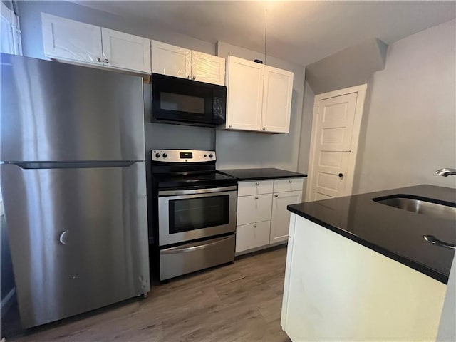 kitchen featuring white cabinetry, sink, dark hardwood / wood-style floors, and appliances with stainless steel finishes