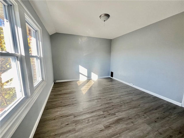 unfurnished room with lofted ceiling and dark hardwood / wood-style floors