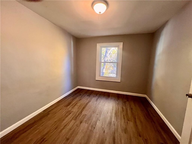 unfurnished room with dark hardwood / wood-style flooring