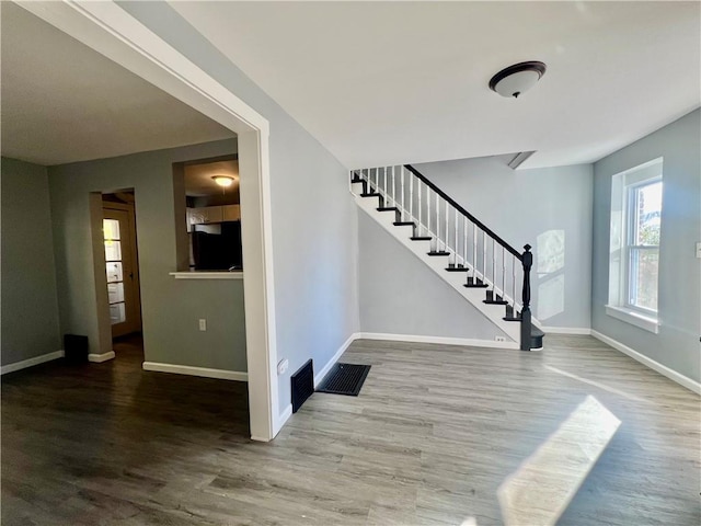 foyer entrance featuring wood finished floors, visible vents, baseboards, and stairs