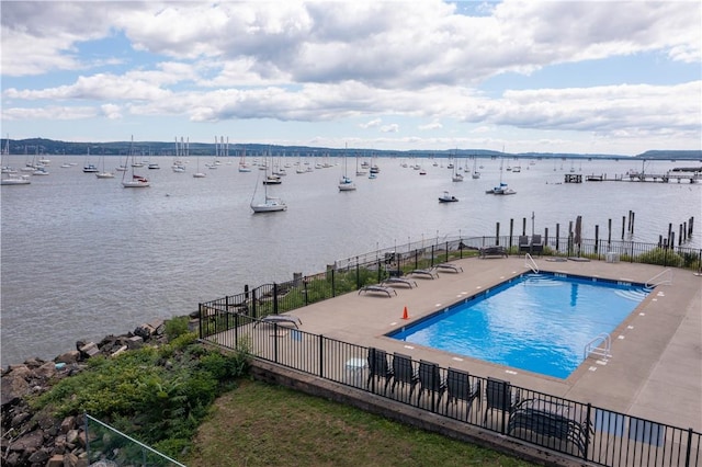 view of pool featuring a water view and a patio