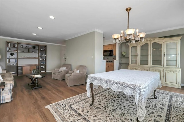 dining room with hardwood / wood-style floors, crown molding, and a notable chandelier