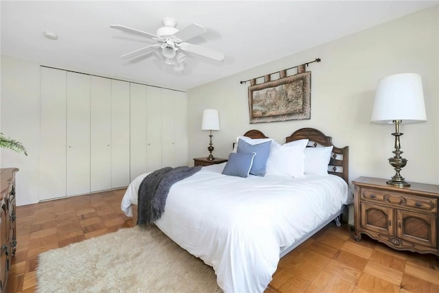 bedroom with ceiling fan, a closet, and light parquet floors