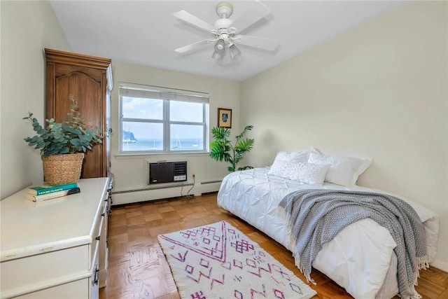 bedroom with ceiling fan, light parquet flooring, and a baseboard radiator