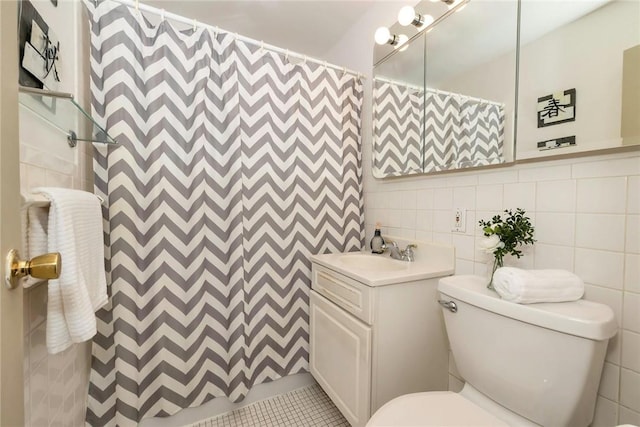 bathroom with a shower with curtain, vanity, tile walls, tile patterned flooring, and toilet