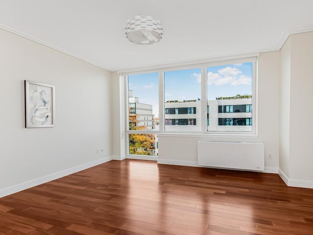 unfurnished room with radiator heating unit, dark hardwood / wood-style floors, floor to ceiling windows, and crown molding