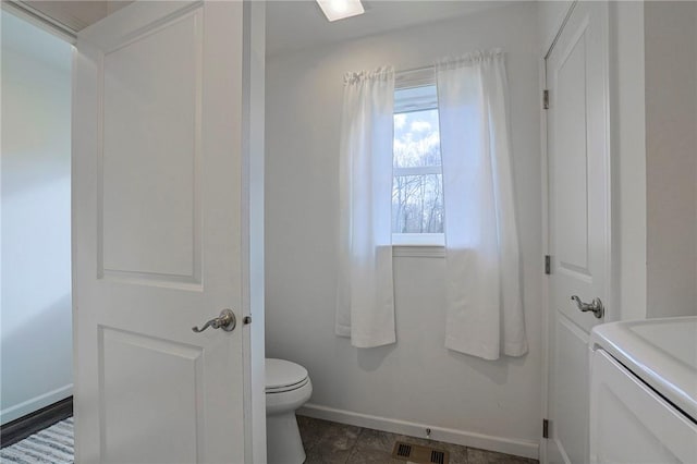 bathroom with toilet and washing machine and dryer