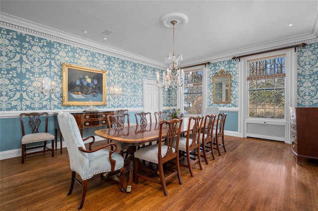 dining room featuring wallpapered walls, wood finished floors, crown molding, and wainscoting